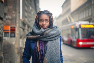 Black woman with braids in winter wearing a protective hairstyle