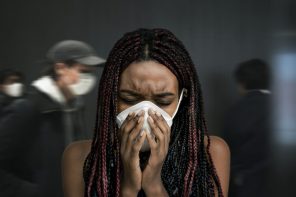 Woman coughing into his mask